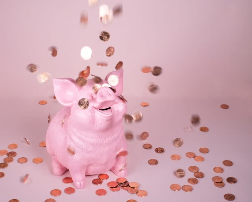 Piggy bank with pennies falling on top.