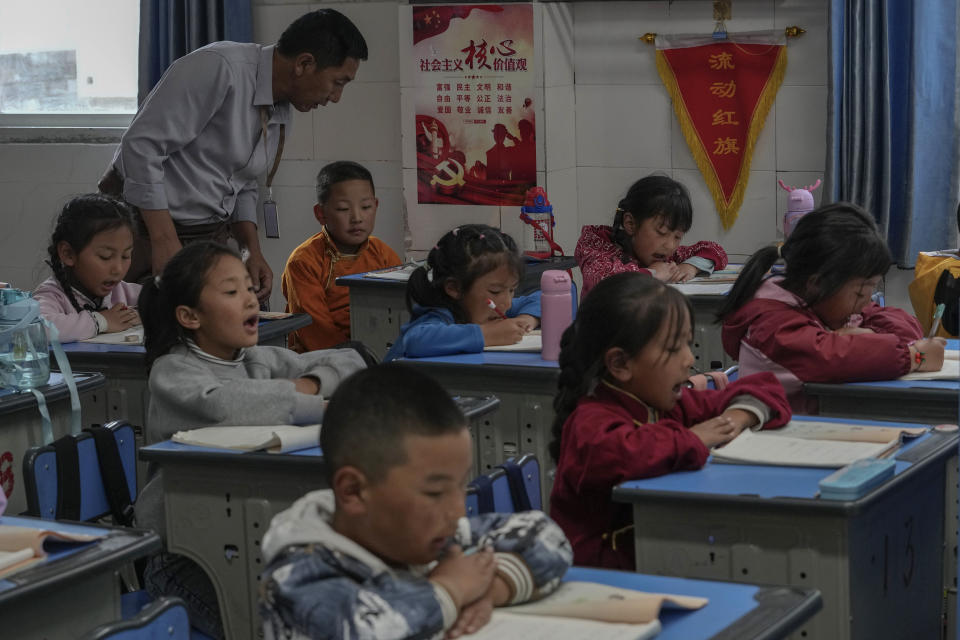 A teacher watches Tibetan students learn to write Tibetan words in a first-grade class at the Shangri-La Key Boarding School during a media-organized tour in Dabpa county, Kardze Prefecture, Sichuan province, Chinaon Sept. 5, 2023. (AP Photo/Andy Wong)