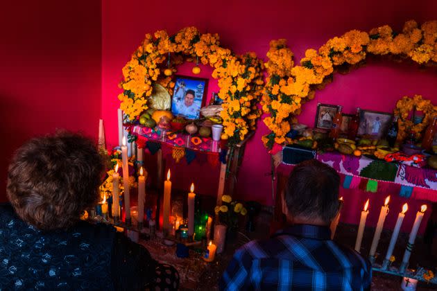 A Mexican couple sits in front of an altar of the dead (Altar de Muertos), a religious site honoring the deceased, during the Day of the Dead (Día de los Muertos) celebrations on Nov. 1, 2021, in Metlatónoc, Mexico. Based on the belief that the souls of the departed may come back to this world on that day, people gather to pray, eat, drink or play music, to remember friends or family members who have died and to support their souls on the spiritual journey. (Photo: Jan Sochor via Getty Images)