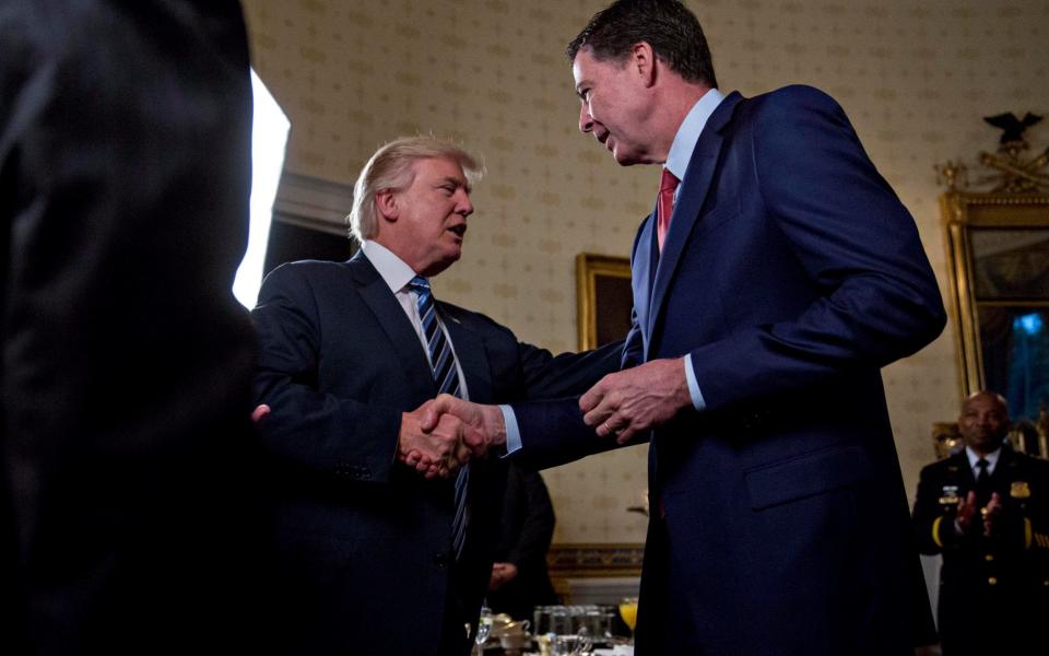 Donald Trump shakes hands with James Comey during an Inaugural Law Enforcement Officers and First Responders Reception in the Blue Room of the White House on January 22 - Credit: Andrew Harrer/Getty Images