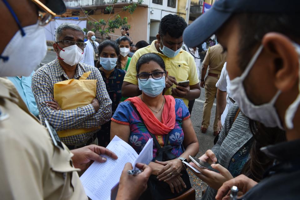 Frontline health workers queue to receive a dose of a Covid-19 coronavirus vaccine at the Cooper hospital in Mumbai on January 16, 2021. (Photo by Punit PARANJPE / AFP) (Photo by PUNIT PARANJPE/AFP via Getty Images)