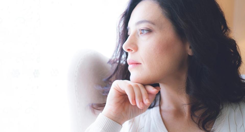 woman looking out window saw, with Seasonal affective disorder SAD. (Getty Images)