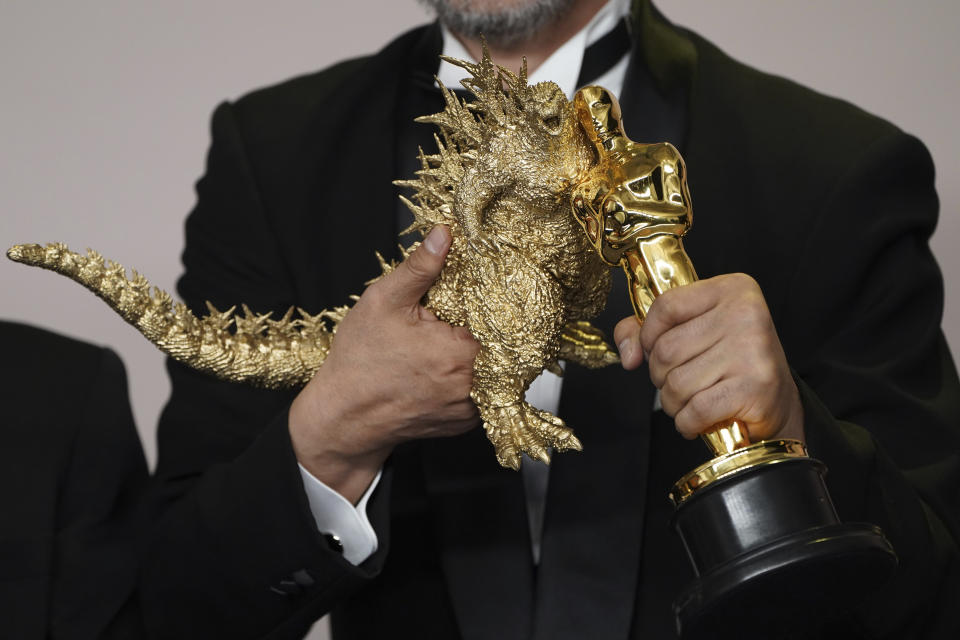 Takashi Yamazaki posa con un muñeco de Godzilla y el premio a mejores efectos visuales por "Godzilla Minus One" en los Oscar el domingo 10 de marzo de 2024, en el Teatro Dolby en Los Angeles. (Foto Jordan Strauss/Invision/AP)