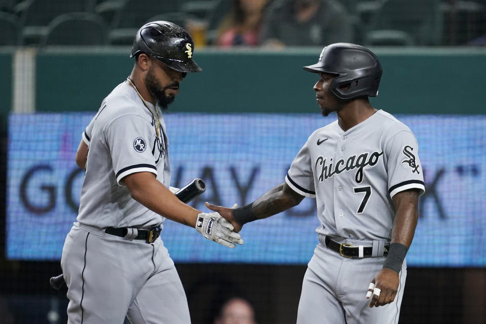 Chicago White Sox's Jose Abreu, left, and Tim Anderson celebrate after Anderson scored on a sacrifice fly by Abreu during the first inning of the team's baseball game against the Texas Rangers in Arlington, Texas, Friday, Sept. 17, 2021. (AP Photo/Tony Gutierrez)