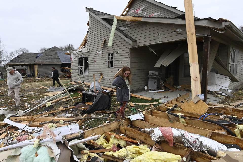 Jennifer Ricer revisa sus pertenencias entre los escombros tras una fuerte tormenta que causó serios daños en su vivienda, el domingo 10 de diciembre de 2023, en Clarksville, Tennessee. (AP Foto/Mark Zaleski)