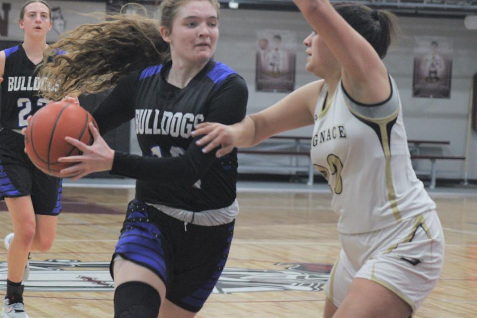 Inland Lakes junior guard Brooklyn LaBrecque (left) drives to the basket while St. Ignace's Gabby Adams defends during the first half of Monday's MHSAA Division 4 girls basketball regional semifinal clash at Harbor Light.