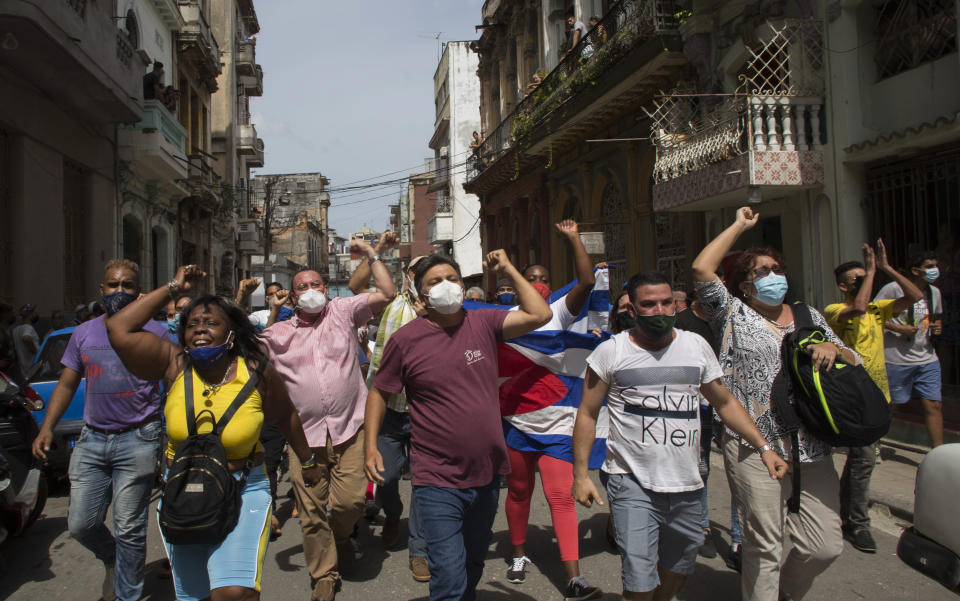 CORRECTS TO PRO-GOVERNMENT SUPPORTERS - Government supporters shout slogans as anti-government protesters march in Havana, Cuba, Sunday, July 11, 2021. Hundreds of demonstrators went out to the streets in several cities in Cuba to protest against ongoing food shortages and high prices of foodstuffs. (AP Photo/Ismael Francisco)