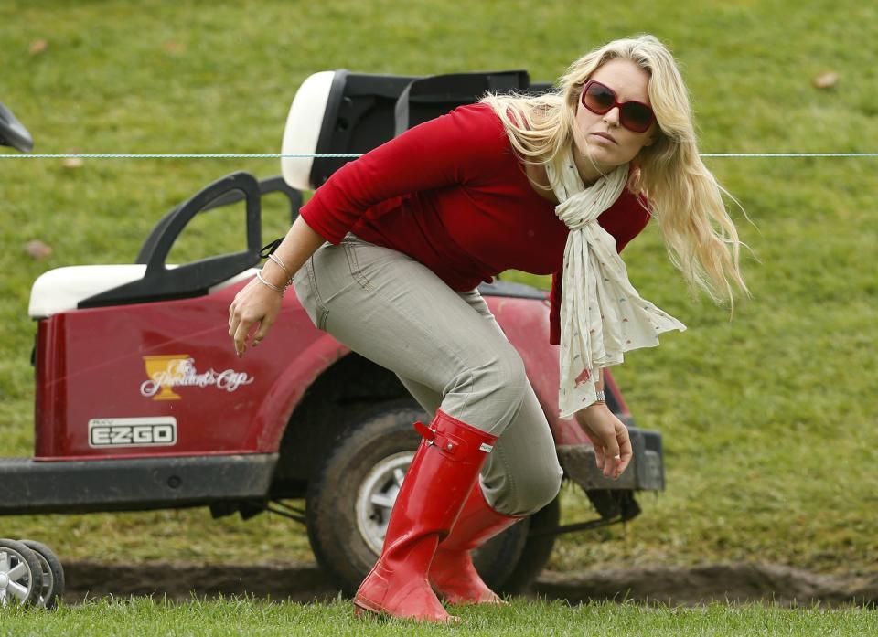 Tiger Wood's girlfriend Lindsey Vonn ducks under a rope during the Singles matches for the 2013 Presidents Cup golf tournament at Muirfield Village Golf Club in Dublin, Ohio October 6, 2013. REUTERS/Chris Keane (UNITED STATES - Tags: SPORT GOLF ENTERTAINMENT)