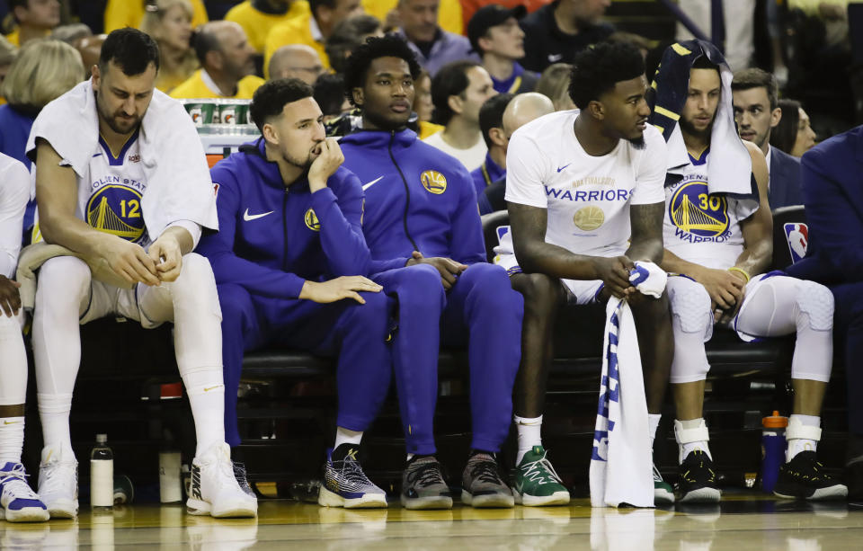 Golden State Warriors guard Klay Thompson, second from left, sits on the bench with teammates during the first half of Game 3 of basketball's NBA Finals against the Toronto Raptors in Oakland, Calif., Wednesday, June 5, 2019. (AP Photo/Ben Margot)