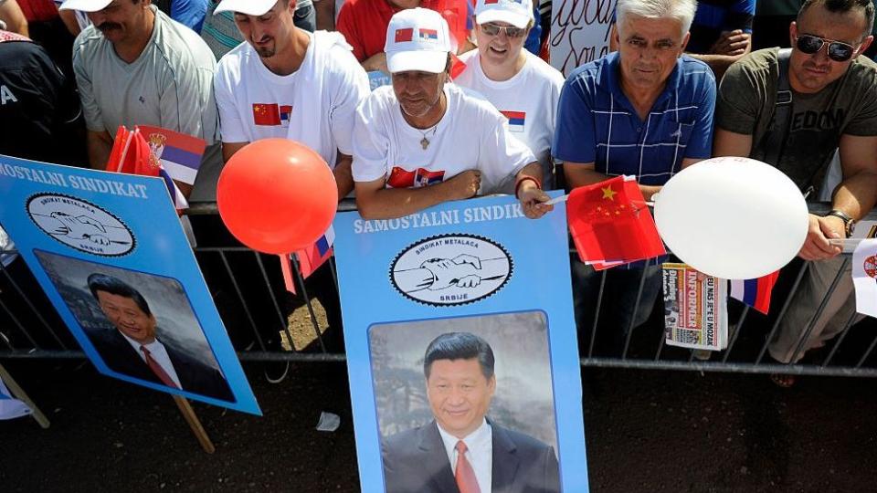 Serbios muestran banderas chinas y carteles con el rostro del presidente chino Xi Jinping.