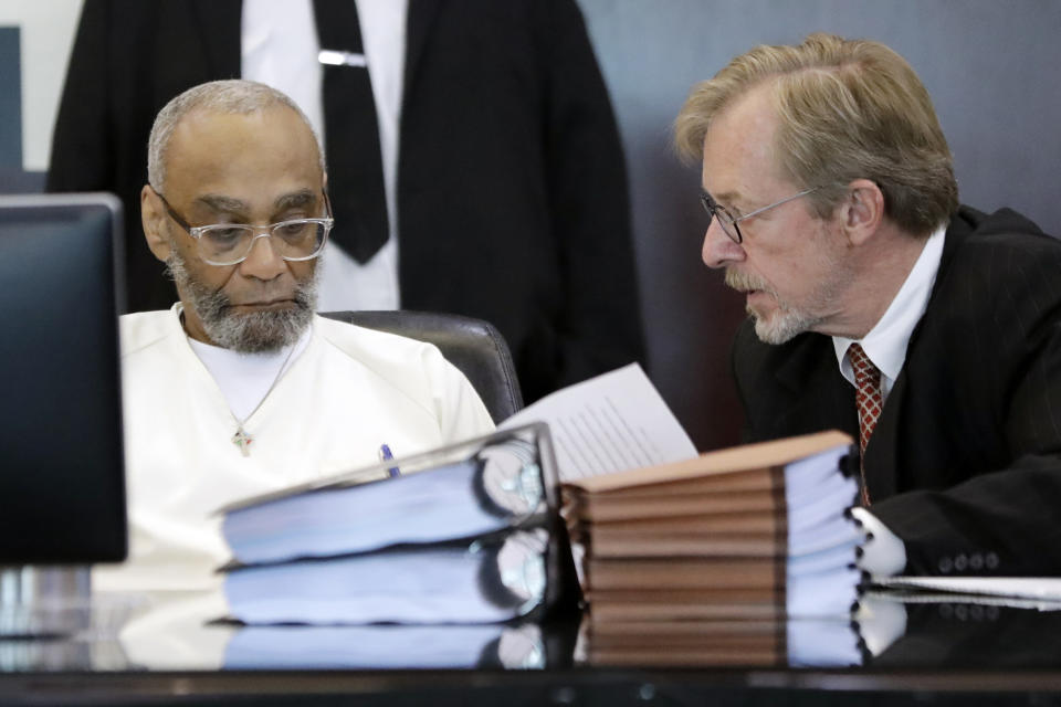 Abu-Ali Abdur'Rahman, left, signs a court order with the help of his attorney, Brad MacLean, right, during a hearing Wednesday, Aug. 28, 2019, in Nashville, Tenn. Abdur'Rahman, who was convicted of murder and is scheduled to be executed next April, claimed that prosecutors' racially motivated dismissal of potential black jurors resulted in an unfair trial. The court order presented at the hearing will convert Abdur'Rahman's death sentence to a sentence of life in prison if approved by the judge. (AP Photo/Mark Humphrey)