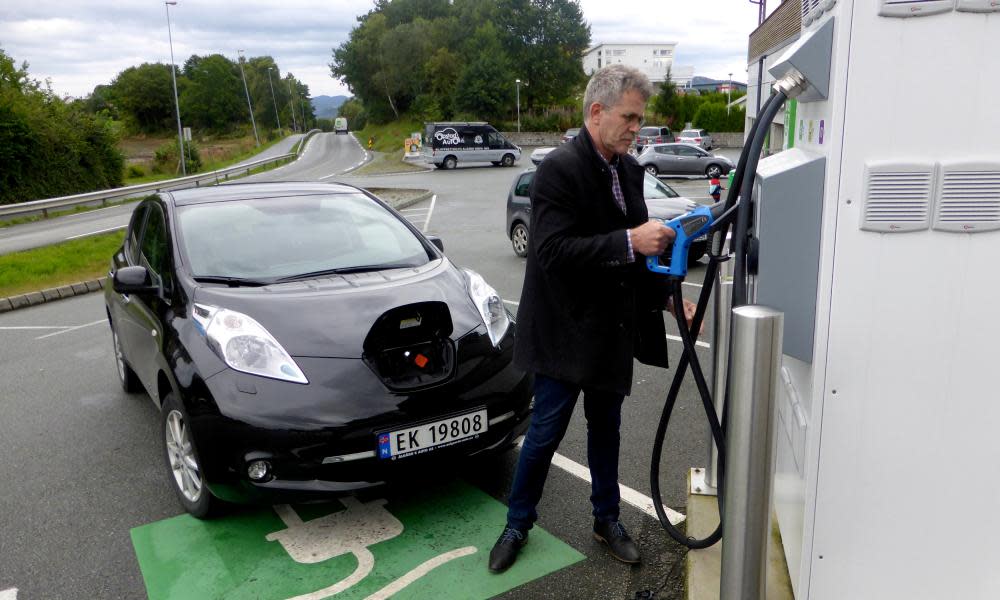 A man recharges his Nissan Leaf electric car in Finnøy, Norway.