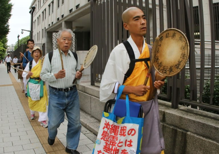 Buddhist monks and followers beat drums and march around the National Diet building in Tokyo on August 28, 2015, to protest against Japanese Prime Minister Shinzo Abe's controversial security bills