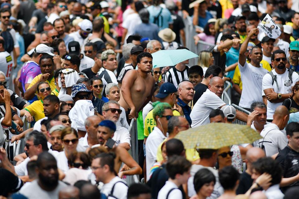 People line up to pay their last respects to the late Brazilian soccer great Pele during his wake at Vila Belmiro stadium in Santos, Brazil