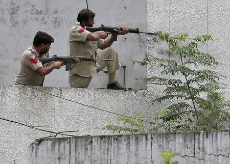 Indian policemen take their positions next to a police station during a gunfight at Dinanagar town in Gurdaspur district of Punjab, India, July 27, 2015. REUTERS/Munish Sharma