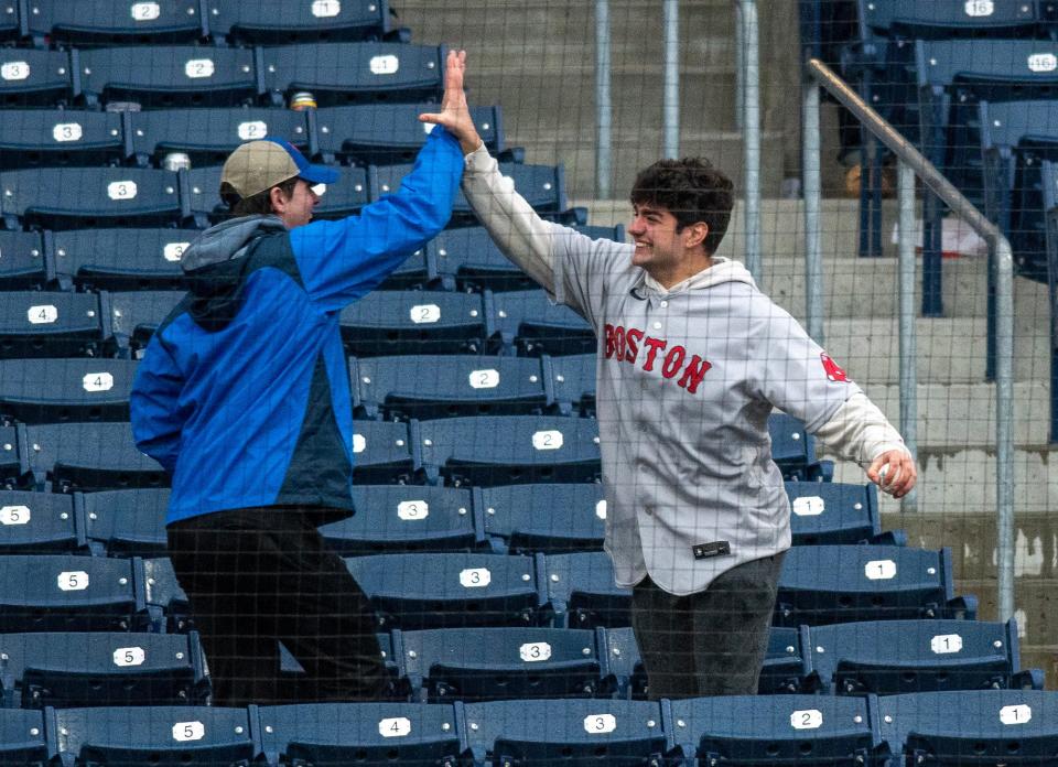 A WooSox fan celebrates getting a foul ball at Polar Park during the home opener.