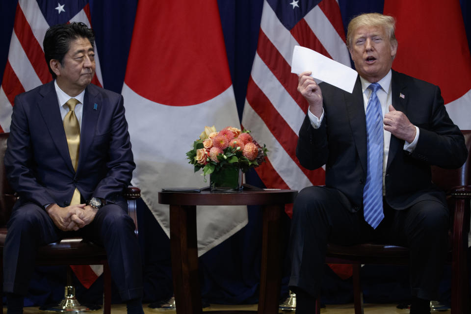 President Donald Trump takes a letter from North Korean leader Kim Jong-un from his suit coat pocket during a meeting with Japanese Prime Minister Shinzo Abe at the Lotte New York Palace hotel during the United Nations General Assembly, Wednesday, Sept. 26, 2018, in New York. (AP Photo/Evan Vucci)