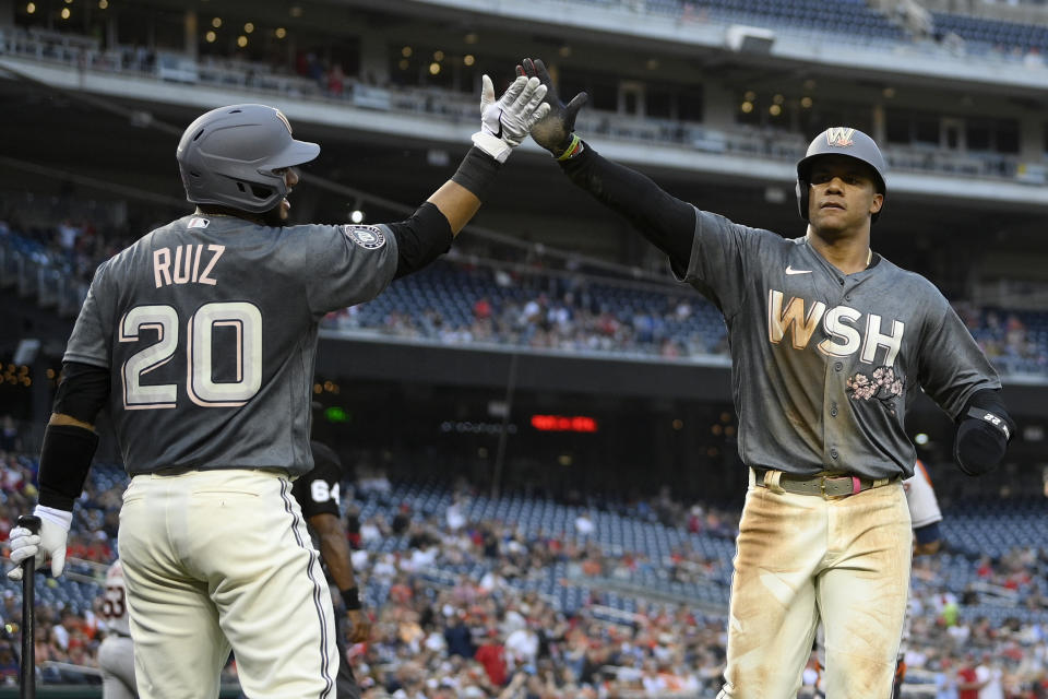 Washington Nationals' Juan Soto, right, gets a high-five from Keibert Ruiz (20) after scoring on a single by Yadiel Hernandez during the first inning of a baseball game against the Houston Astros, Saturday, May 14, 2022, in Washington. (AP Photo/Nick Wass)