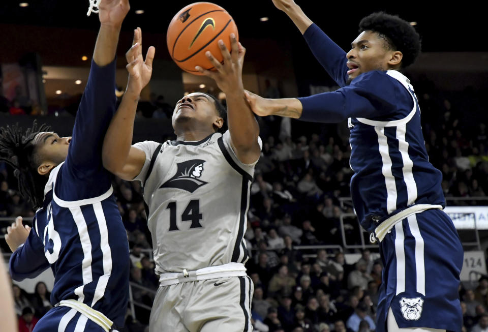 Butler's Jayden Taylor, left, and Jalen Thomas, right, put the squeeze on Providence's Corey Floyd, Jr. (14) under the net during the first half of an NCAA college basketball game, Wednesday, Jan. 25, 2023, in Providence, R.I. (AP Photo/Mark Stockwell)