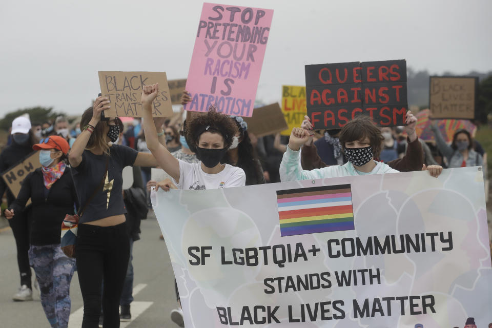 Angela Rose, center, marches with gay activists and suppoters on the Great Highway at Ocean Beach in San Francisco, Sunday, June 14, 2020, at a protest over the Memorial Day death of George Floyd, who died after being restrained by Minneapolis police. (AP Photo/Jeff Chiu)