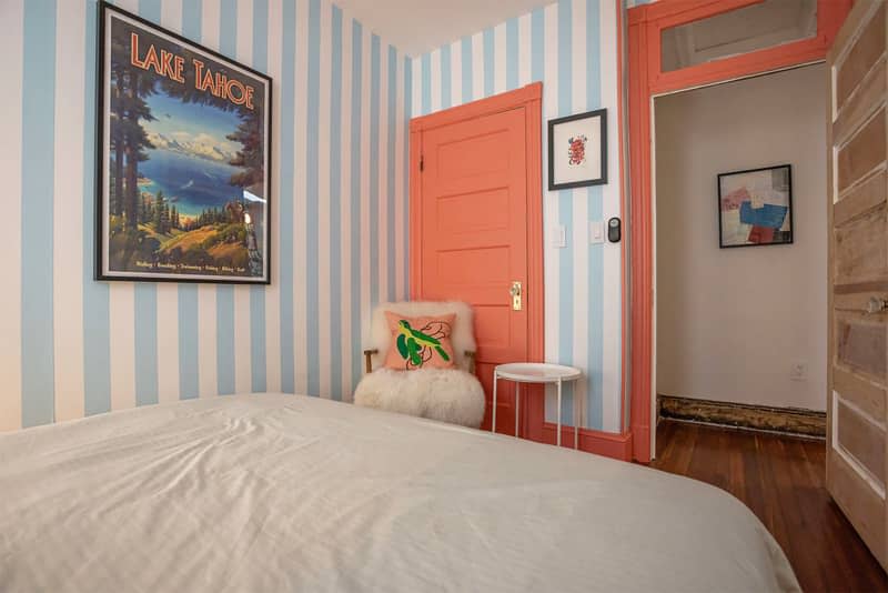 Blue and white striped wallpaper in bedroom with terra cotta painted doors and trim.