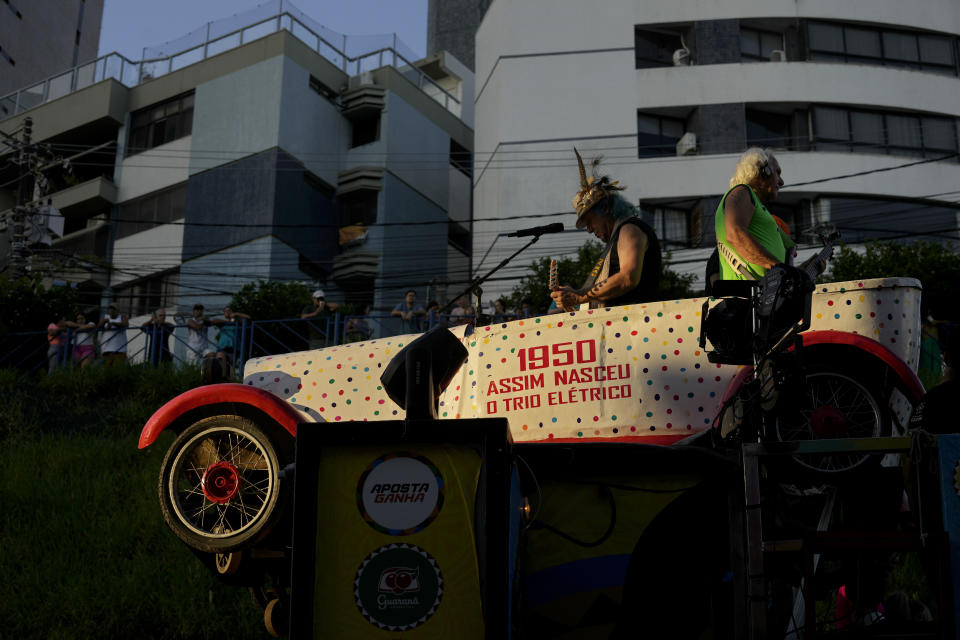 Armandinho Macedo, left center, and Betinho Macedo, sons of Trio Eletrico co-founder Osmar Macedo, parade in a replica of their father’s 1929 Ford Model A, in Salvador, Bahia state, Brazil, Sunday, Feb. 4, 2024. In 1950, Osmar, as he is universally known, and his friend Dodô, a radio technician and fellow amateur musician, outfitted the Ford with two speakers and connected their guitar and cavaquinho to the car’s battery, and drove it through the streets to the delight of carnival revelers. (AP Photo/Eraldo Peres)