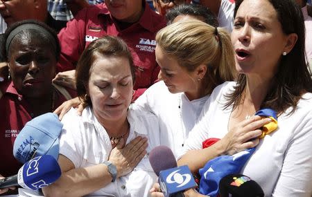Mitzy de Ledezma (2nd L), wife of arrested Caracas metropolitan mayor Antonio Ledezma, reacts next to Lilian Tintori (2nd R), wife of jailed opposition leader Leopoldo Lopez, and opposition leader Maria Corina Machado (R), during a gathering in support of him in Caracas Febreuary 20, 2015. REUTERS/Carlos Garcia Rawlins