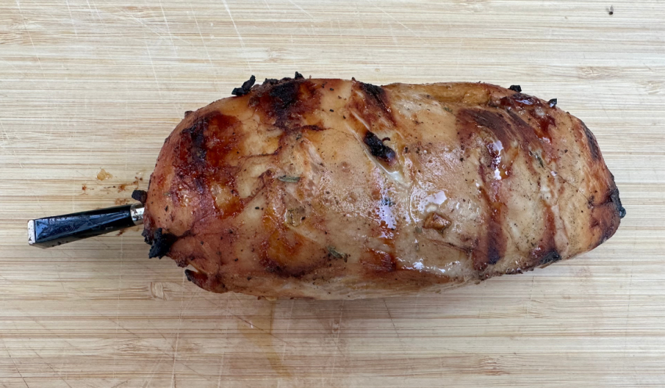 grilled chicken breast on cutting board with probe inside