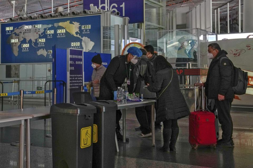 Passenger wearing face masks line up for security check before entering an international departure gate at the Beijing Capital International Airport in Beijing, Thursday, Dec. 29, 2022. Moves by the U.S., Japan and others to mandate COVID-19 tests for passengers arriving from China reflect global concern that new variants could emerge in its ongoing explosive outbreak — and the government may not inform the rest of the world quickly enough. (AP Photo/Andy Wong)
