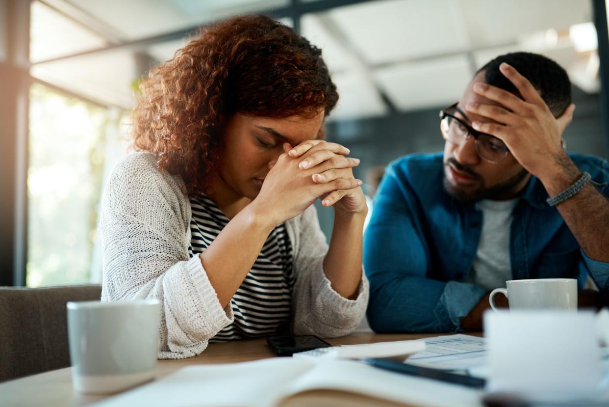 Shot of a young couple looking stressed out while working on their budget at home