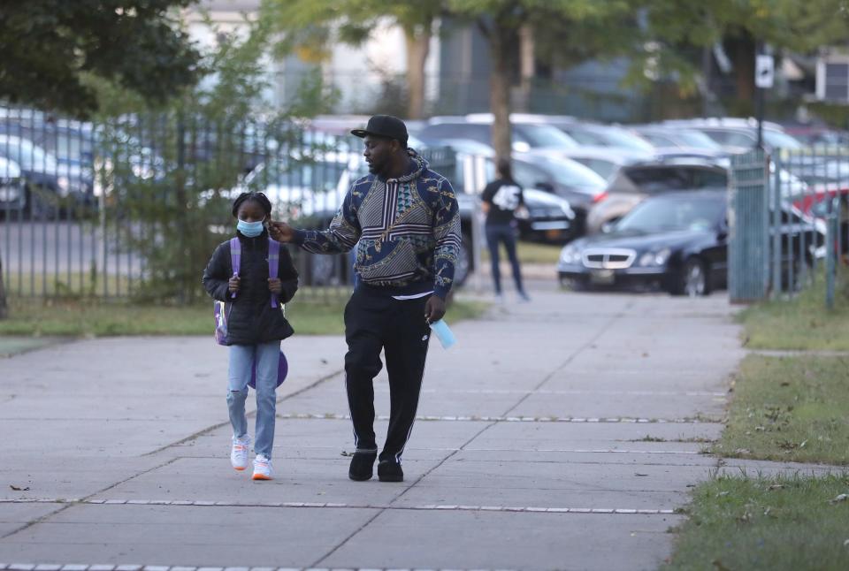 Kamora Porchea, first grader, walks into School 45 in Rochester with her father, Jermi, on September 9, 2021.  Today was the first day for the city as well as a few other area school districts.  