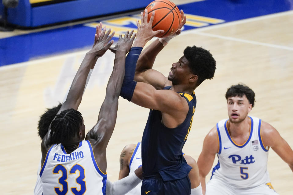 West Virginia's Mohamed Wague, second from right,shoots over Pittsburgh's Federiko Federiko (33) during the second half of an NCAA college basketball game, Friday, Nov. 11, 2022, in Pittsburgh. (AP Photo/Keith Srakocic)