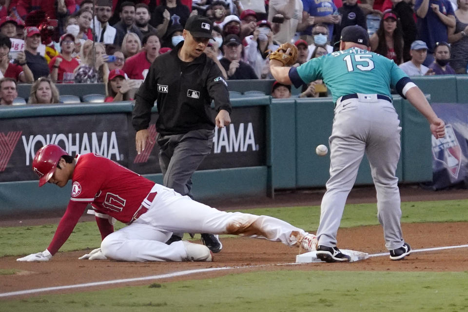 Los Angeles Angels designated hitter Shohei Ohtani, left, is safe at third for an RBI triple as Seattle Mariners third baseman Kyle Seager, right, drops the ball during the first inning of a baseball game Saturday, Sept. 25, 2021, in Anaheim, Calif. (AP Photo/Mark J. Terrill)