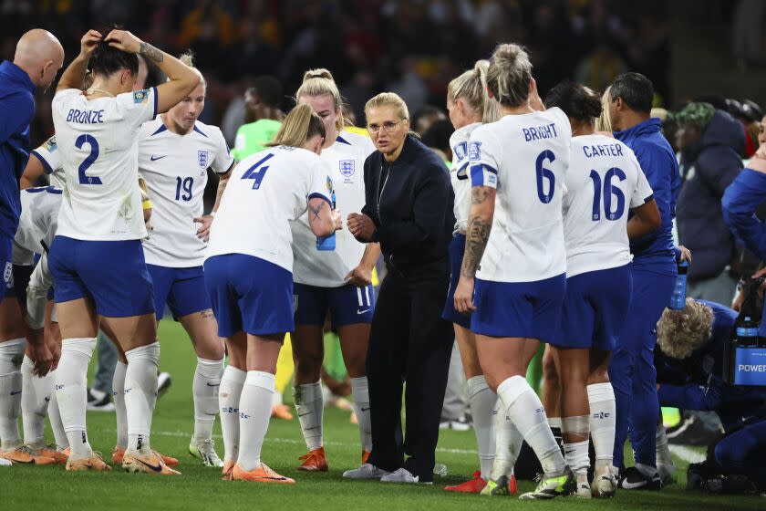 England's coach Sarina Wiegman, center, talks with players during a World Cup match against Nigeria