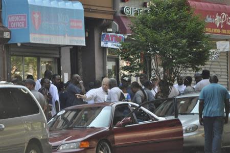 Astramed Physicians clinic's Dr. Robert Terdiman (white shirt, pointing) is pictured in front of the Astramed Physicians clinic in New York, in this July 9, 2013 handout surveillance photo provided by the Office of the Special Narcotics Prosecutor for the City of New York. REUTERS/Office of the Special Narcotics Prosecutor for the City of New York/Handout via Reuters