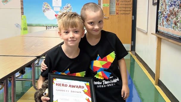 PHOTO: Garrett Brown holds his 'hero award' certificate as Cashton York poses alongside him, at their school in Norman, Okla. (KOCO-TV)