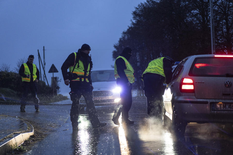 A police officers check documents at a checkpoint near the scene of a blast in Przewodow, Poland, Wednesday, Nov. 16, 2022. Poland said Wednesday that a Russian-made missile fell in the country’s east, though U.S. President Joe Biden said it was “unlikely” it was fired from Russia. (AP Photo/Evgeniy Maloletka)