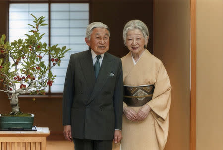 FILE PHOTO: Japan's Emperor Akihito (L) exchanges smiles with Empress Michiko at the Imperial Palace in Tokyo, in this handout photo taken September 29, 2015 and released by the Imperial Household Agency of Japan. REUTERS/Imperial Household Agency of Japan/Handout via Reuters/File photo