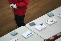 A man wearing gloves walk in a polling station after picking up ballots for local elections in Lyon, central France, Sunday, March 15, 2020. France is holding nationwide elections Sunday to choose all of its mayors and other local leaders despite a crackdown on public gatherings because of the new virus. For most people, the new coronavirus causes only mild or moderate symptoms. For some it can cause more severe illness. (AP Photo/Laurent Cipriani)