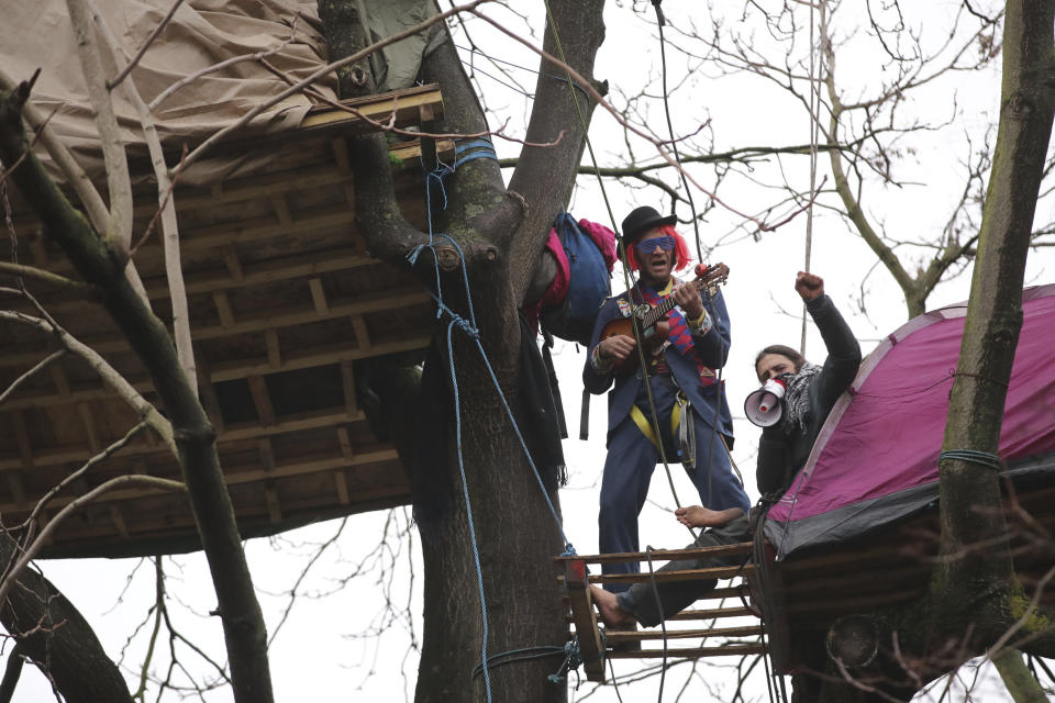 Protesters in trees at the encampment in Euston Square Gardens in central London, Wednesday Jan. 27, 2021. Protesters against a high-speed rail link between London and the north of England said Wednesday that some of them have been evicted from a park in the capital after they dug tunnels and set up a makeshift camp. (Aaron Chown/PA via AP)