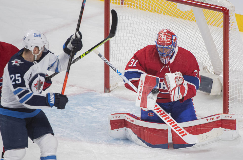 Montreal Canadiens goaltender Carey Price makes a save as Winnipeg Jets' Paul Stastny moves in for the rebound during the first period of an NHL hockey game Saturday, March 6, 2021, in Montreal. (Graham Hughes/The Canadian Press vIa AP)