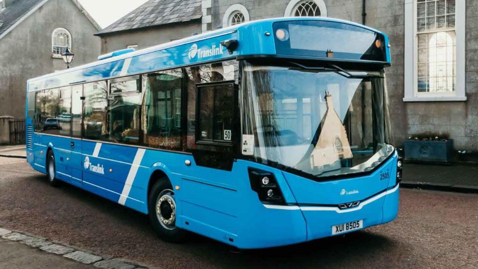 a blue bus parked on the side of a street