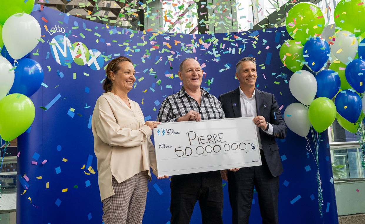 Pierre Richer holding a cheque worth $50,000,000 after winning a Lotto Max jackpot