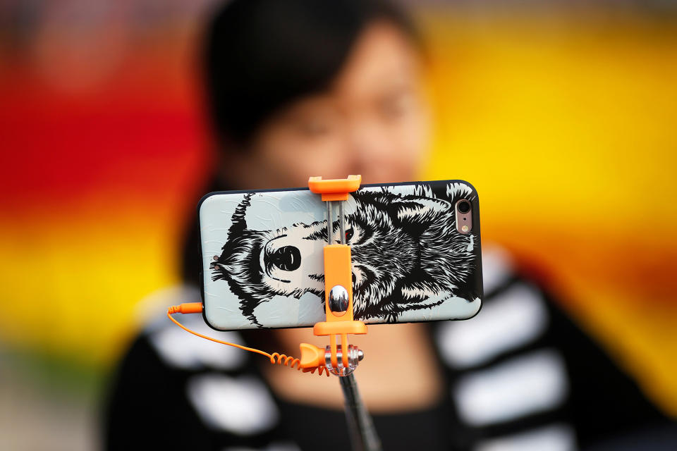 <p>A woman takes pictures of herself as people gather in Tiananmen Square to celebrate National Day marking the 67th anniversary of the founding of the People’s Republic of China, in Beijing October 1, 2016. (REUTERS/Damir Sagolj) </p>