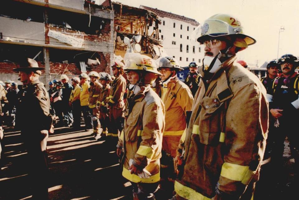 Firefighters and other first responders pause for a moment of silence for the victims of the Alfred Murrah Federal Building car bomb explosion, in Oklahoma City on April 26, 1995.