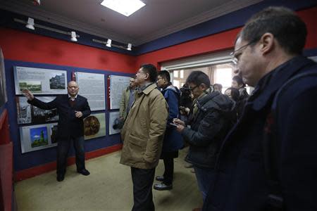 Journalists listen to instructions as they visit the John Rabe Memorial Hall during a reporting trip in Nanjing, Jiangsu province February 20, 2014. REUTERS/Aly Song