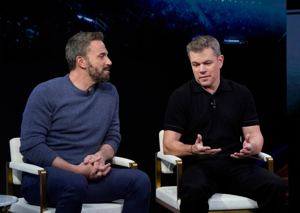 Ben and Matt seated, engaging in a discussion, Matt gesturing with his hands. They are casually dressed