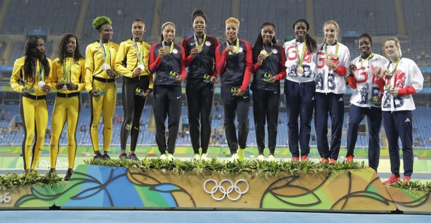 Women's 1,600-meter relay teams from Jamaica, U.S., and Great Britain stand together on the podium during the 2016 Olympics.