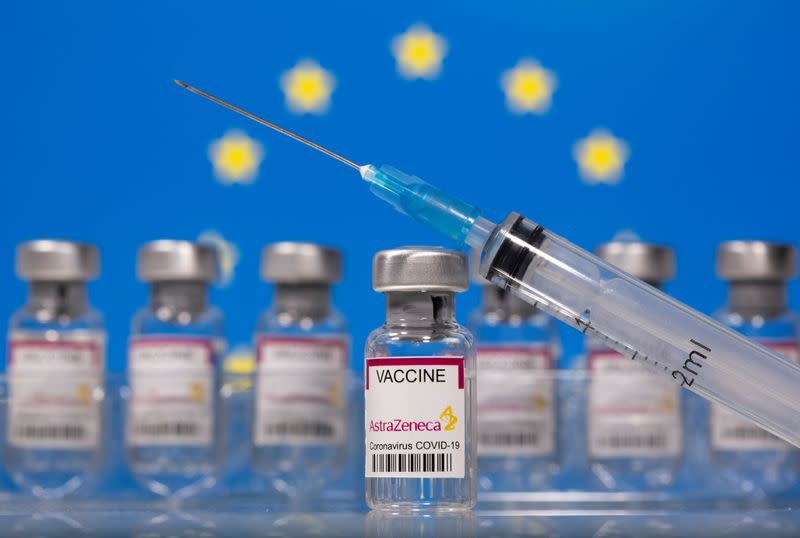 FILE PHOTO: Vials labelled "Astra Zeneca COVID-19 Coronavirus Vaccine" and a syringe are seen in front of a displayed EU flag