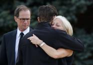 People hug after the funeral of Jordan Segura in Calgary, Alberta April 21, 2014. Matthew de Grood has been charged with killing Segura and four of his friends at a house party last week in Calgary's worst mass murder in the history of the city, according to local media reports. REUTERS/Todd Korol (CANADA - Tags: CRIME LAW OBITUARY)